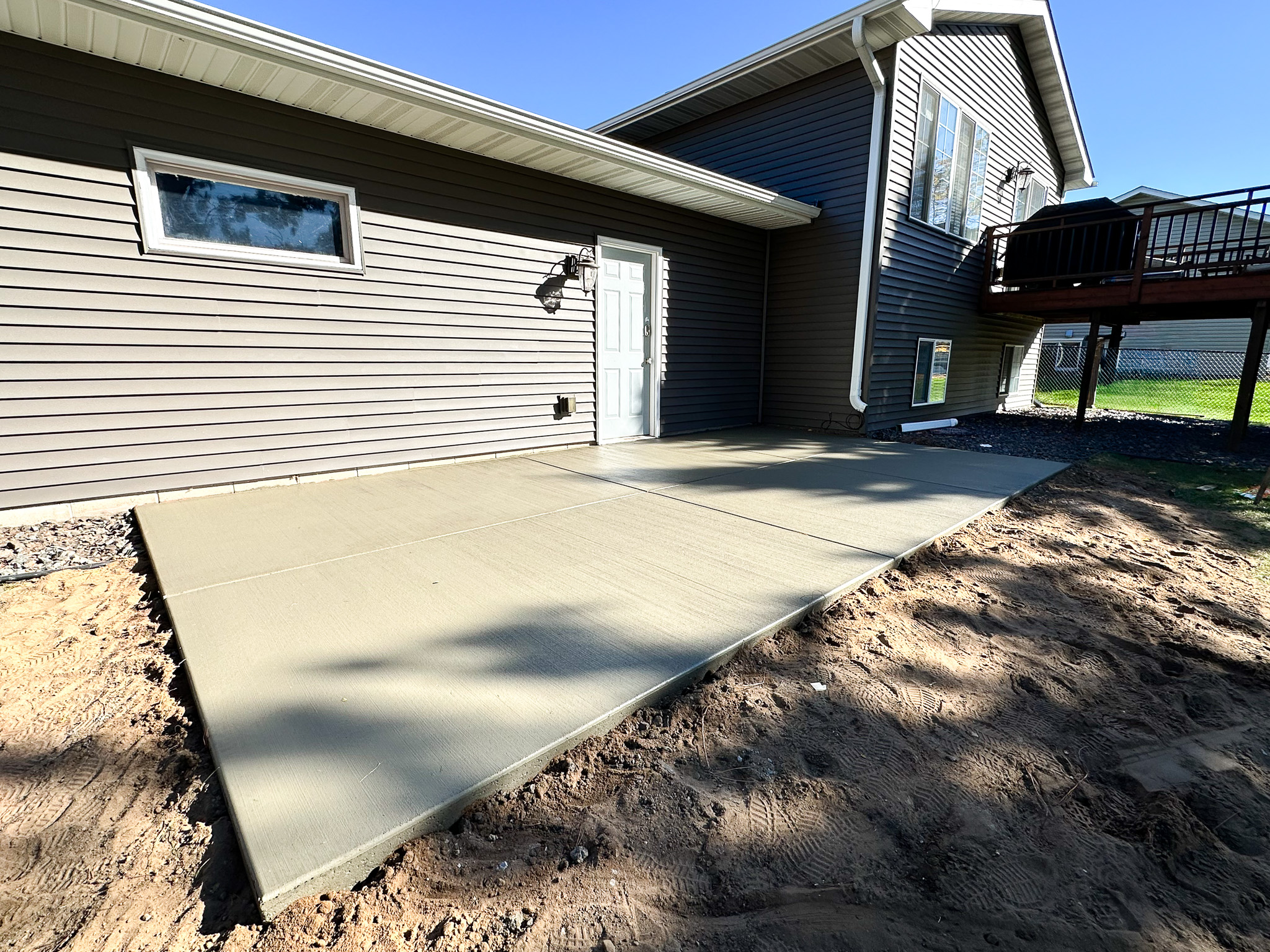 Side yard concrete patio installation by A&J Custom Concrete in Coon Rapids, MN